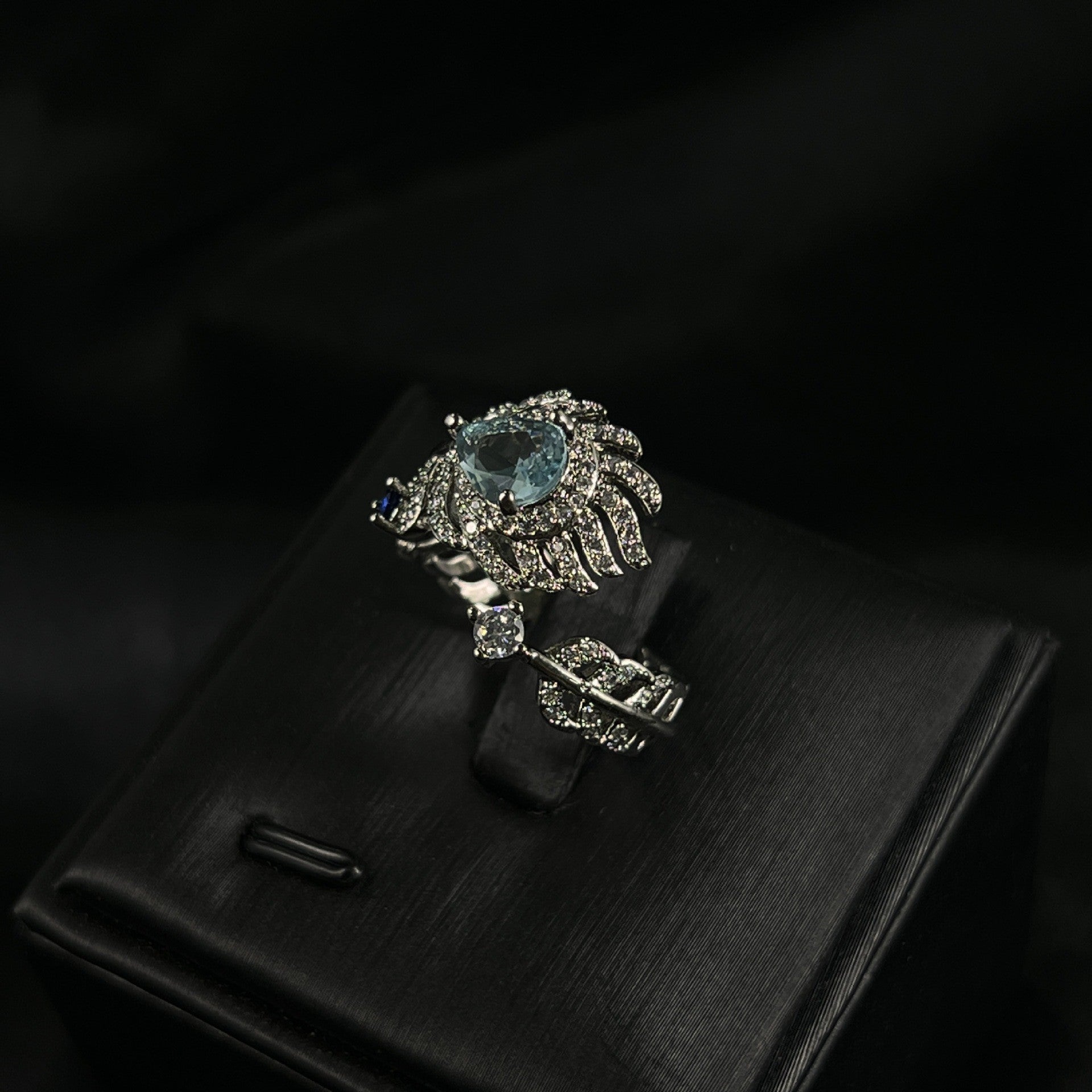 Eleganter Damenring im Feder-Design mit hellblauem Stein