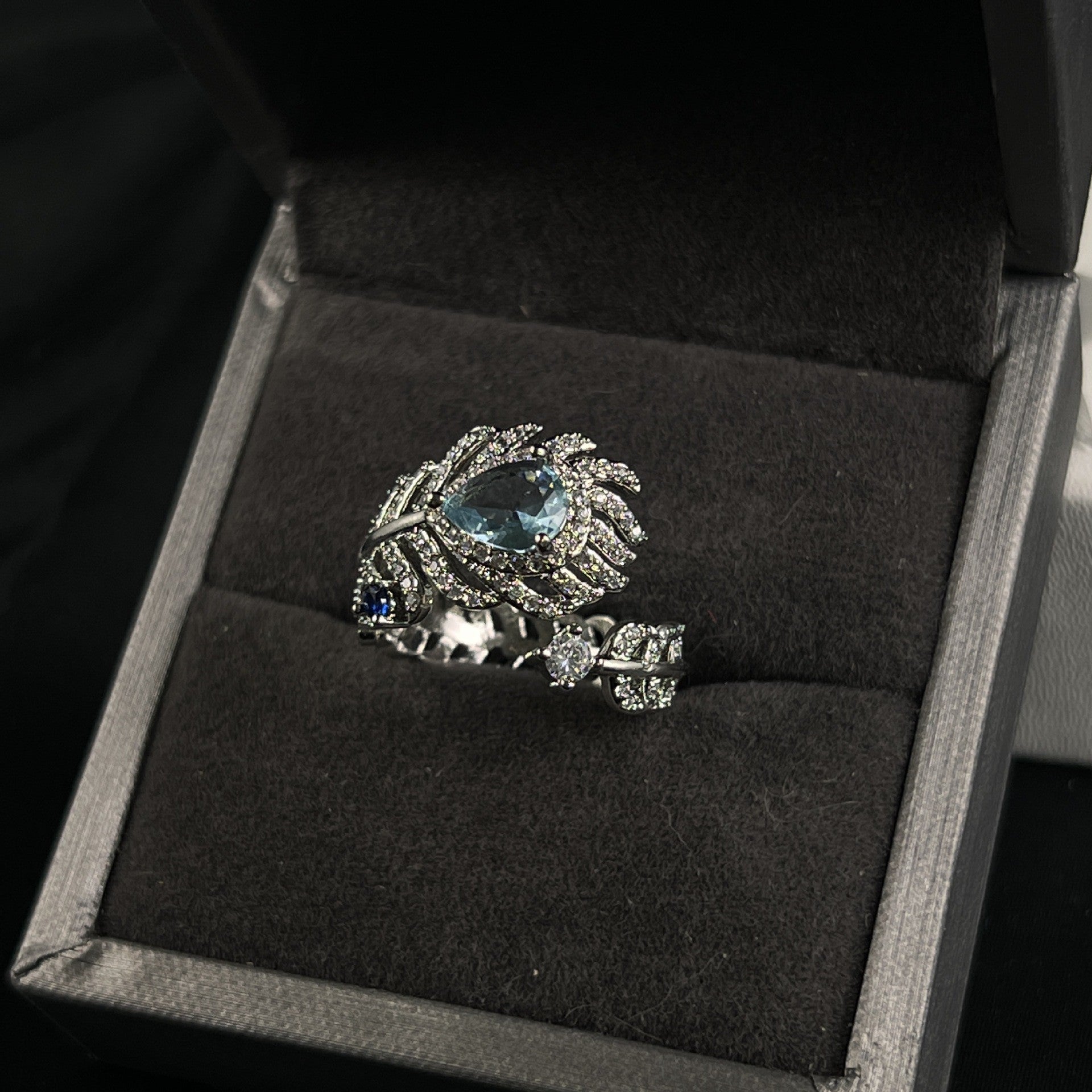 Eleganter Damenring im Feder-Design mit hellblauem Stein